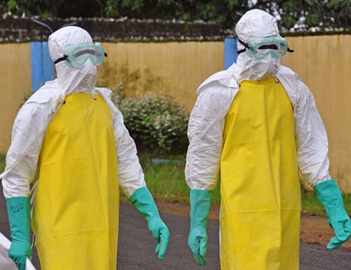 Health workers wearing protective gear go to remove the body of a person who is believed to have died after contracting the Ebola virus in the city of Monrovia, Liberia, Saturday, Aug. 16, 2014. AP photo