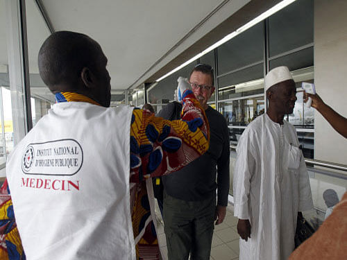 Health workers take passengers' temperatures infrared digital laser thermometers at the Felix Houphouet Boigny international airport in Abidjan. A 35-year-old Nigerian woman, who was travelling to India for treatment of cancer, died here today while in transit after showing symptoms similar to those of deadly Ebola virus, UAE health officials said. Reuters photo