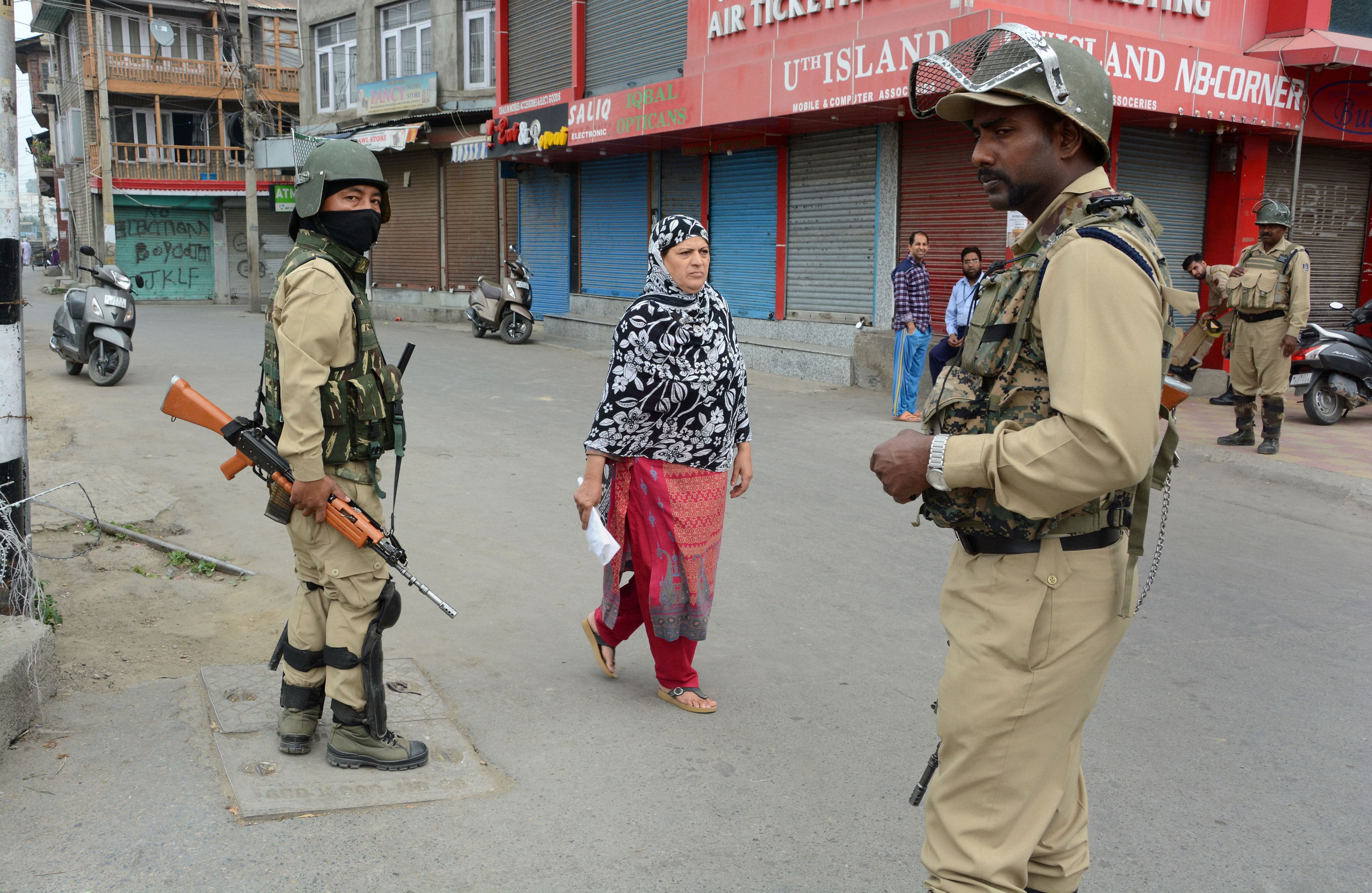 Security personnel stand guard in a market during restrictions after the abrogration of Article 370 and bifurcation of State, in Srinagar