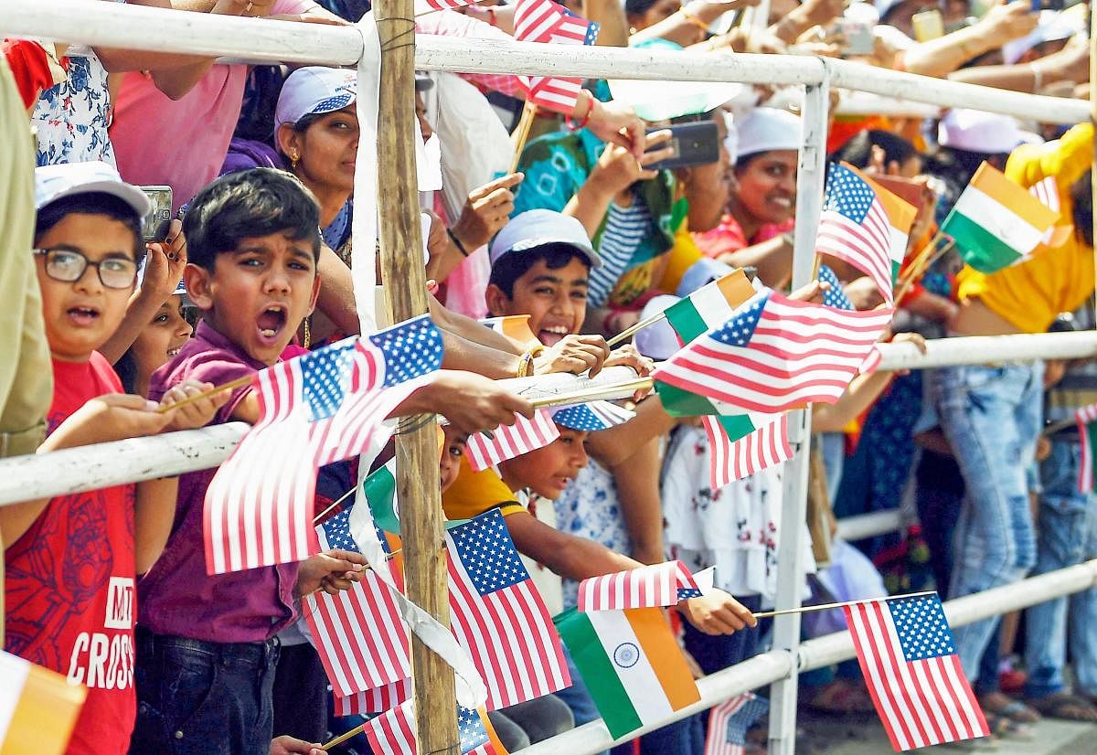 Children wave US and Indian flags as they welcome US President Donald Trump and First Lady Melania Trump during a roadshow in Ahmedabad, Monday, Feb. 24, 2020. Trump is on a two-day visit to India. (PTI Photo) 