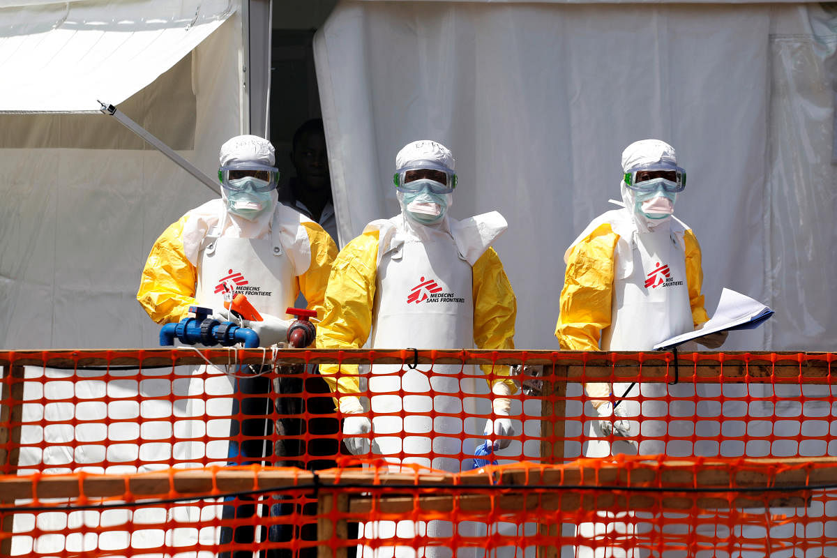 Health workers dressed in protective suits. Photo by REUTERS