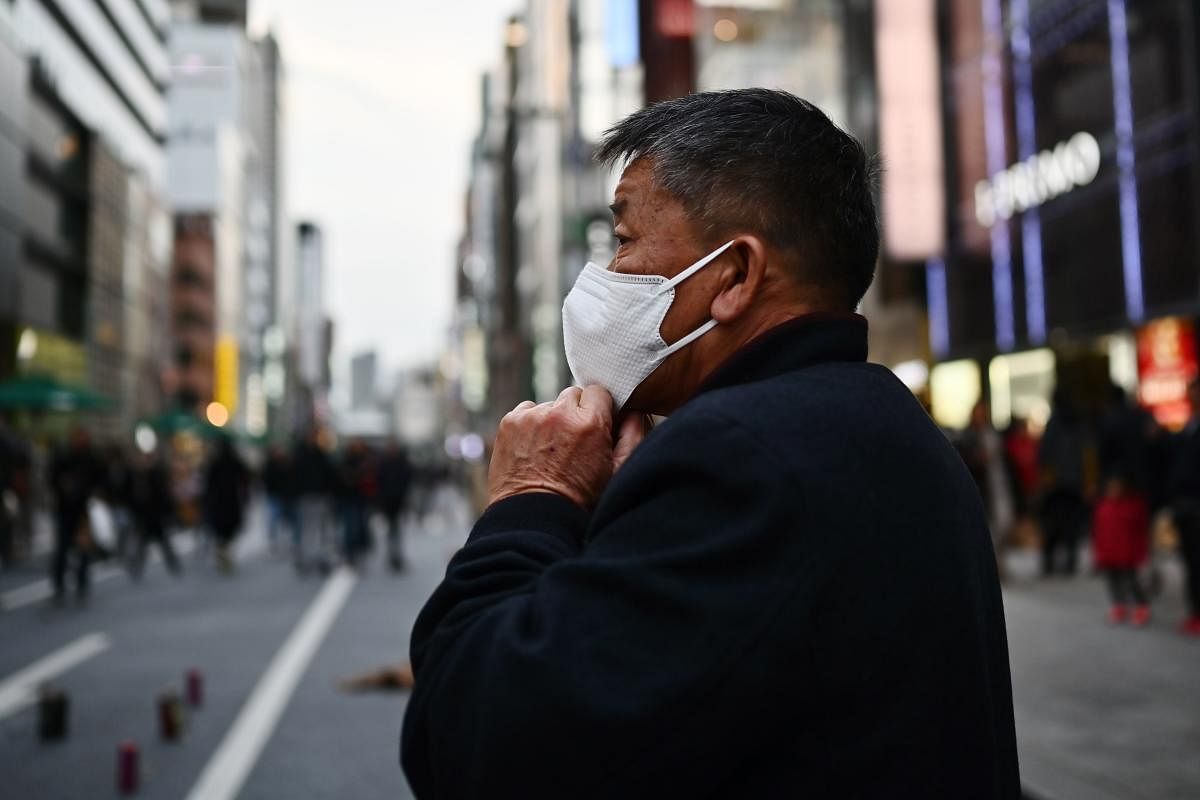 A man wearing a protective mask to help stop the spread of a deadly virus which began in the Chinese city of Wuhan, walks on a street in Tokyo's Ginza area on January 25, 2020. (AFP Photo)