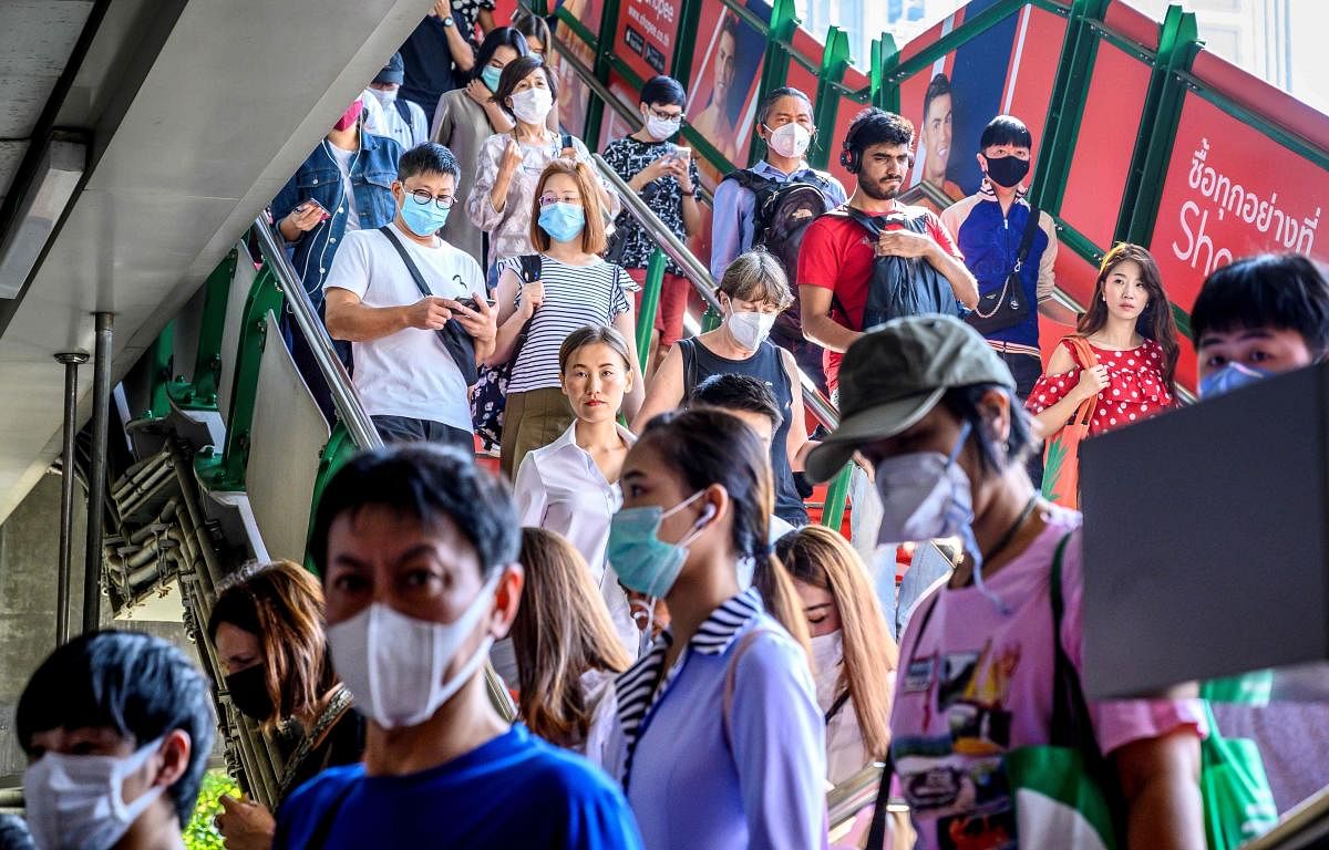 People with face masks arrive at a BTS Sky train station in Bangkok on January 27, 2020. - Thailand has detected eight Coronavirus cases so far. (AFP Photo)