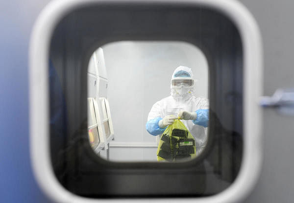 A worker in a protective suit examines specimens inside a laboratory following an outbreak of the novel coronavirus in Wuhan, Hubei province, China February 6, 2020. (Reuters Photo)