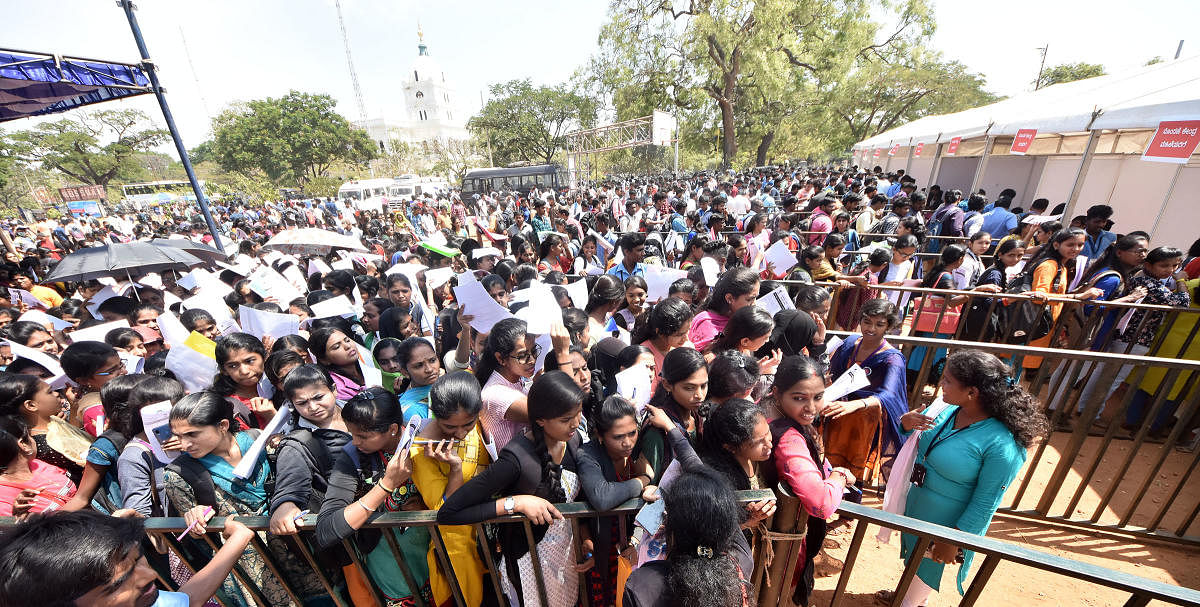 Hundreds of job aspirants throng Scouts and Guides Grounds to participate in a job mela in Mysuru on Wednesday. dh photo