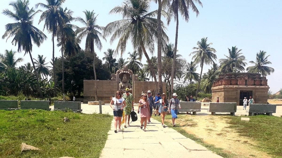 Foreign tourists at Ugra Narasimha monument in Hampi, Hosapete taluk. DH PHOTO