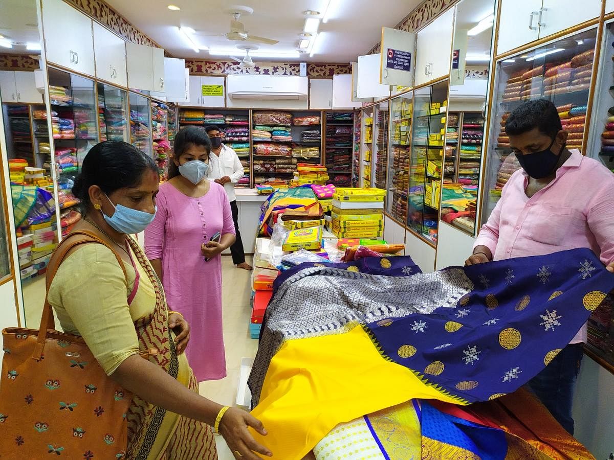 Customer looking at a saree in a cloth store in Mangaluru. DH PHoto