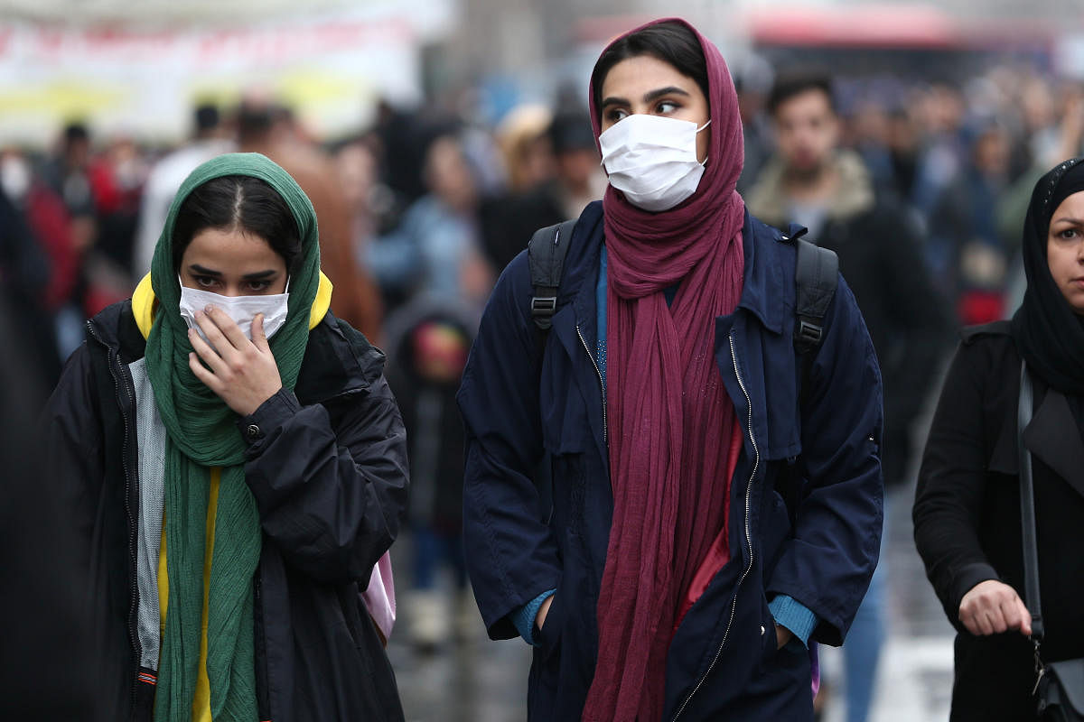 Iranian women wear protective masks to prevent contracting a coronavirus, as they walk at Grand Bazaar in Tehran. Credit: Reuters Photo