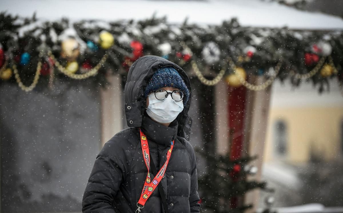 In this file photo taken on January 29, 2020 A tourist wearing a medical mask walks along a street in Moscow. AFP
