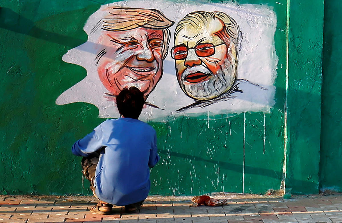 A man applies finishing touches to paintings of U.S. President Donald Trump and India's Prime Minister Narendra Modi on a wall as part of a beautification along a route that Trump and Modi will be taking during Trump's upcoming visit, in Ahmedabad, India, February 17, 2020. (Reuters Photo)