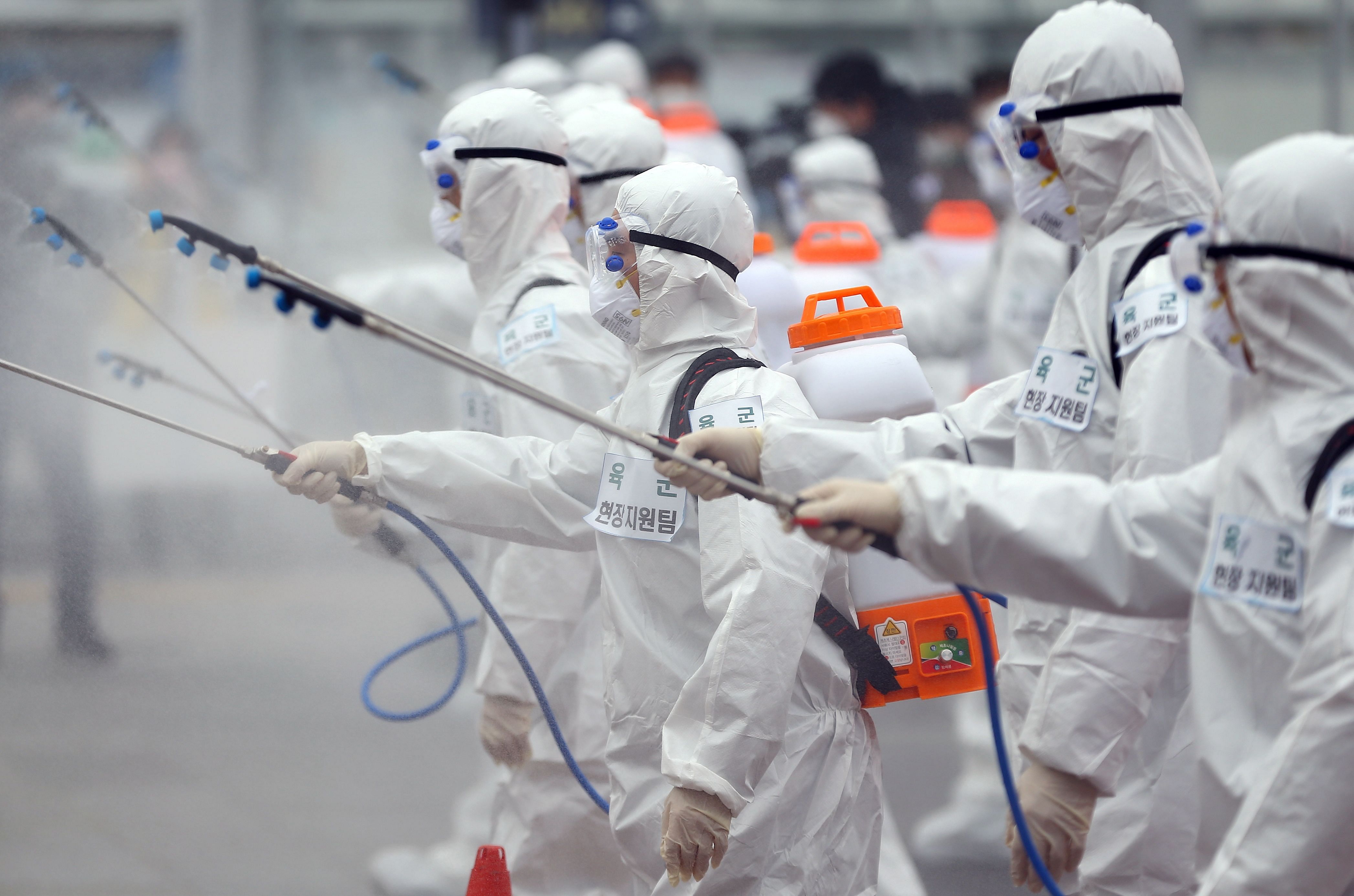 South Korean soldiers wearing protective gear spray disinfectant as part of preventive measures against the spread of the COVID-19 coronavirus, at Dongdaegu railway station in Daegu. (AFP Photo)
