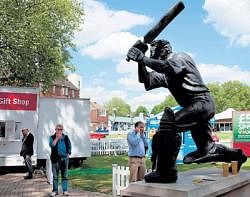 Bridging the gap: Cricket fans stand near the statue of a batsman at Lords cricket ground in London. NYT