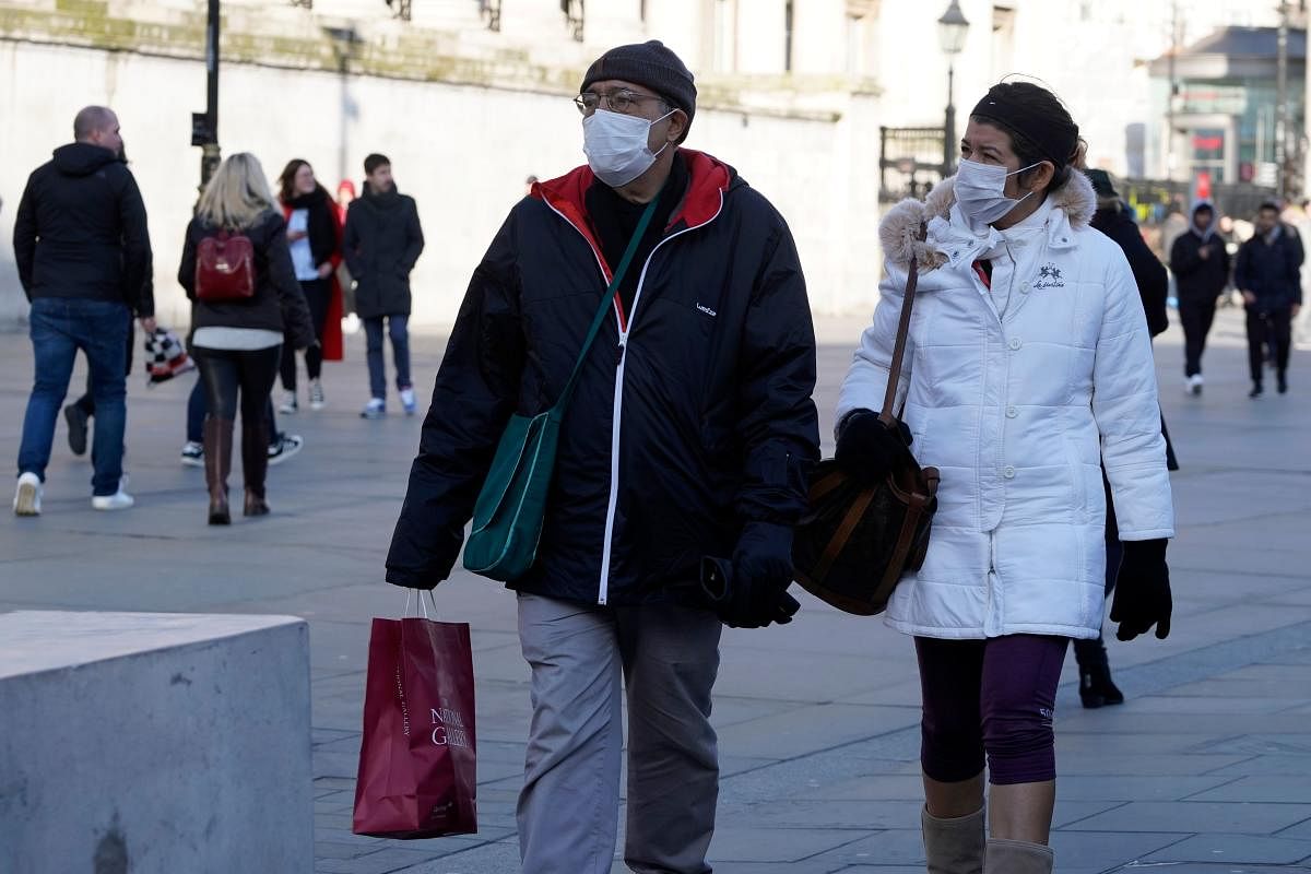 Pedestrians wear surgical masks as they shop in central London on February 27, 2020. - European and US stock markets slumped heavily again Thursday as new coronavirus infections spread outside China. Credit: AFP Photo