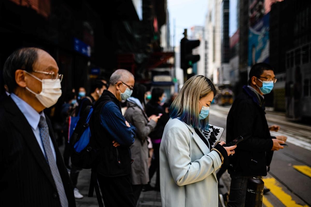 Pedestrians wear face masks, as a preventative measure against the COVID-19 coronavirus, as they walk on a footbridge (AFP Photo)