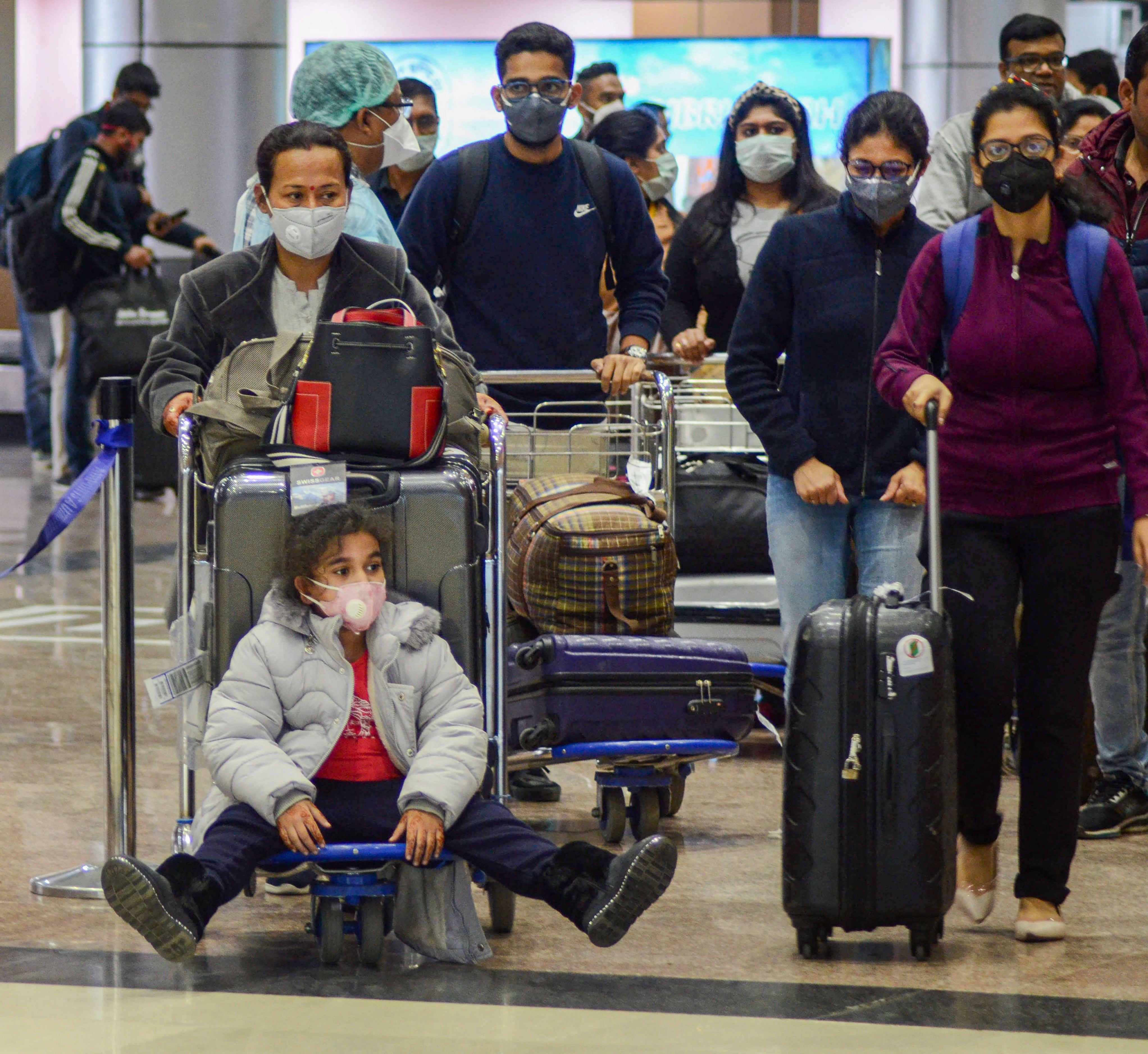 People wear masks as they arrive at an international airport in India. (Credit: PTI)