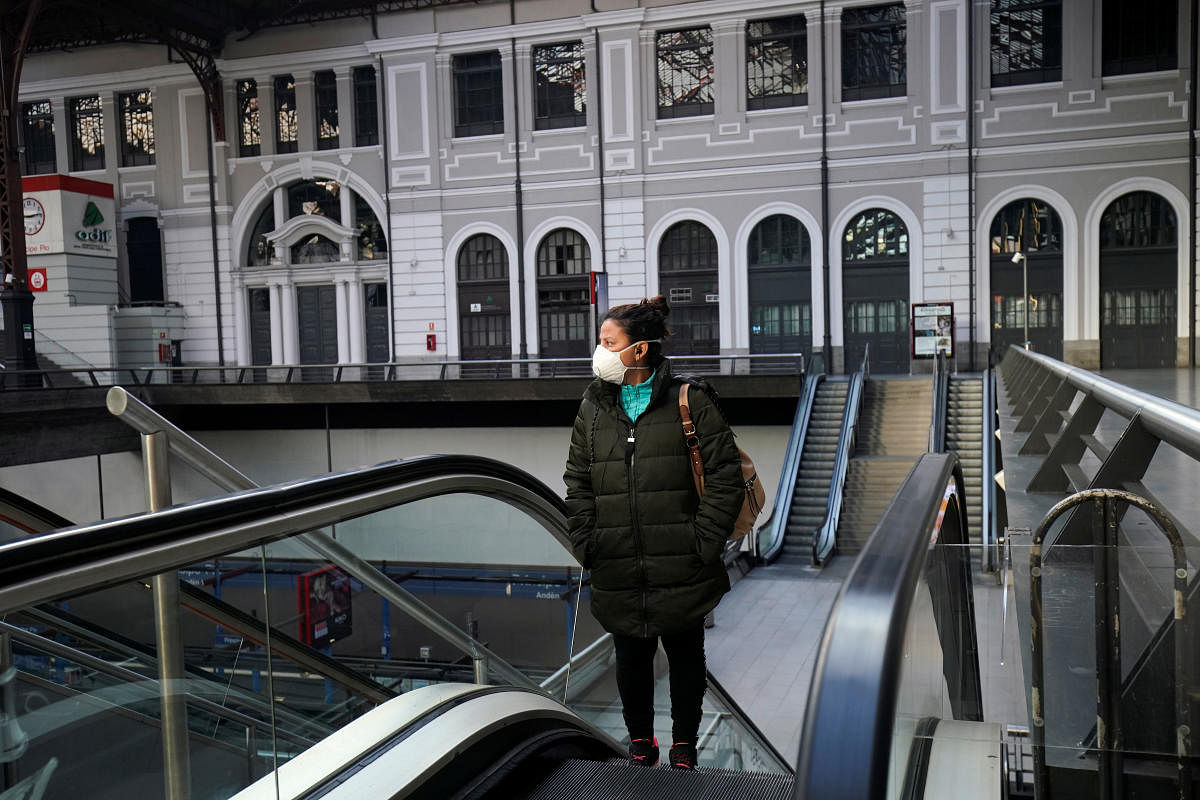 A woman stands on an escalator at an almost empty Principe Pio train station during partial lockdown as part of a 15-day state of emergency to combat the coronavirus disease outbreak in Madrid. Credit: Reuters Photo