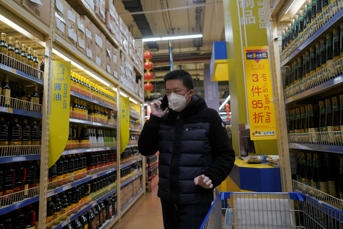 Customer wearing a face mask speaks on his mobile phone inside a supermarket, as the country is hit by an outbreak of the novel coronavirus, in Beijing. Reuters