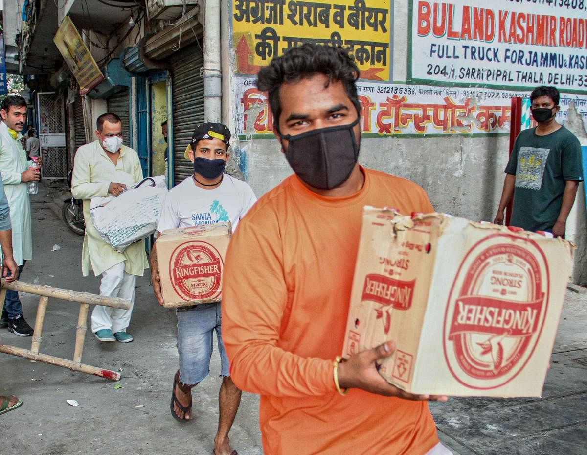 eople leave after purchasing liquor from a wine shop during the third phase of the COVID-19 lockdown, near Azadpur Sabzi Mandi in New Delhi. PTI