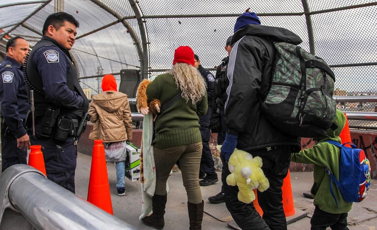 Agents of the Office of Customs and Border Protection allow access to the United States to a group of 33 migrants who are to request political asylum in the US, at the Paso del Norte International Bridge in Ciudad Juarez, Chihuahua State, Mexico. AFP phot