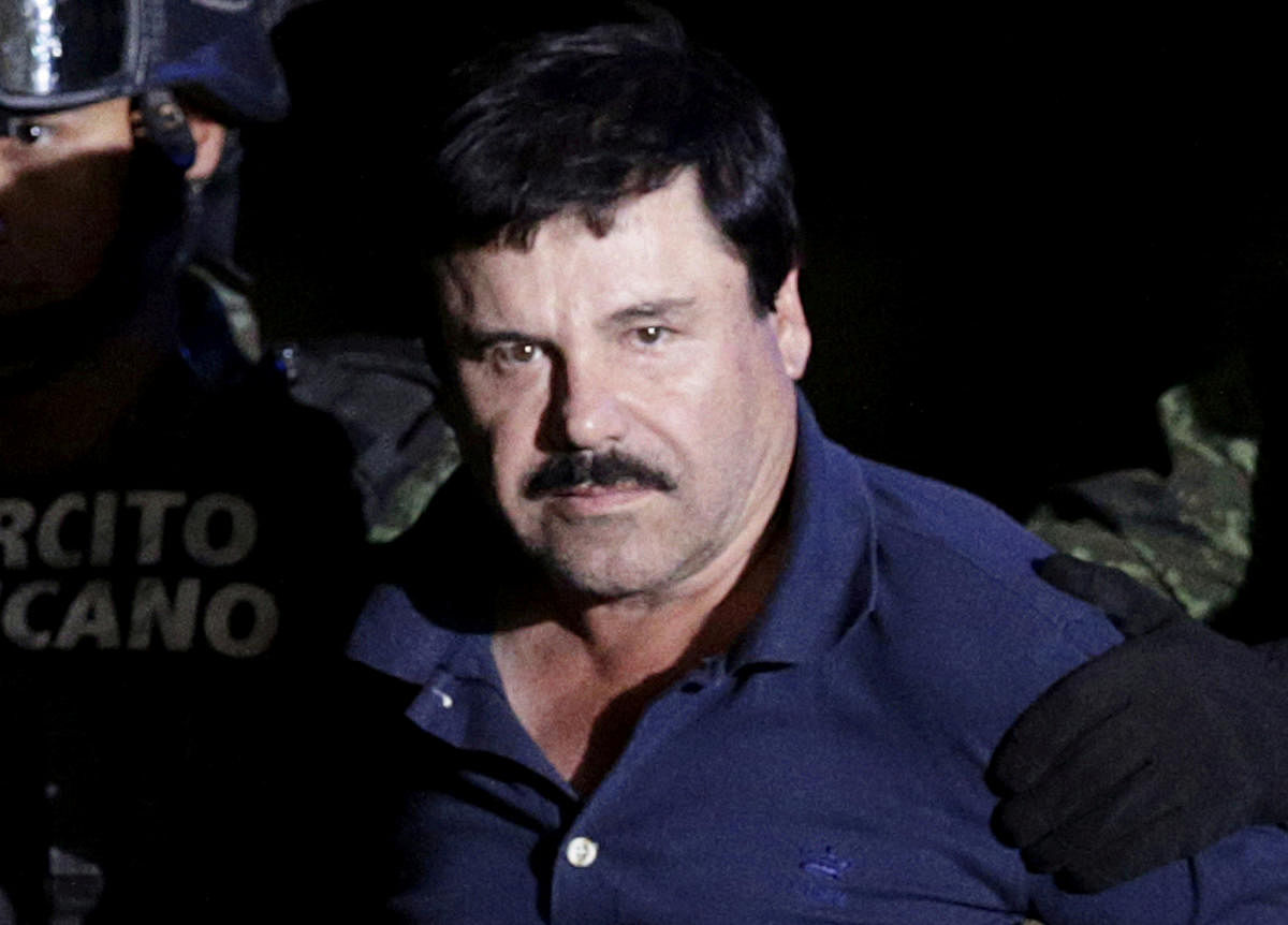 Recaptured drug lord Joaquin "El Chapo" Guzman is escorted by soldiers at the hangar belonging to the office of the Attorney General in Mexico City, Mexico January 8, 2016. (Credit: REUTERS Photo)