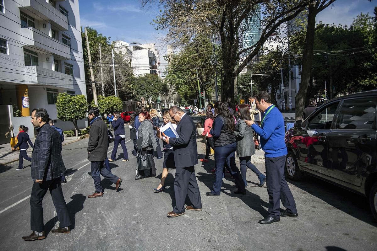 People wait on the streets after an earth tremor in Mexico City. AFP