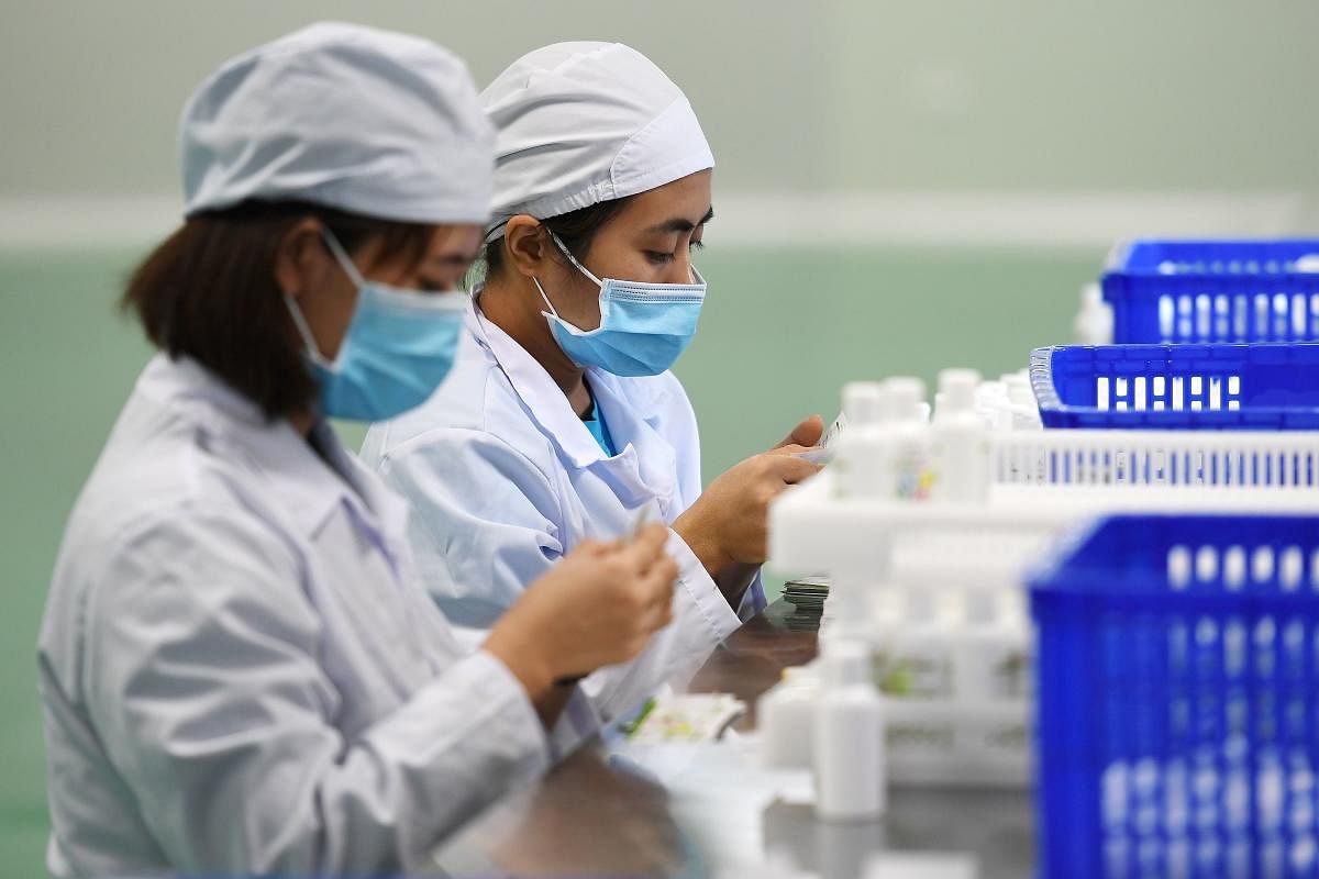 Workers manufacture hand sanitizer at a factory in Hanoi on February 14, 2020 amid concerns of the COVID-19 coronavirus outbreak. (Photo by AFP)