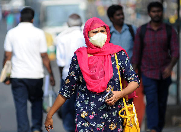 A woman with a mask on seen at Bengaluru Majestic BMTC Bus Stand in wake of COVID-19 outbreak in Bengaluru on Saturday. (DH Photo/ Pushkar V)