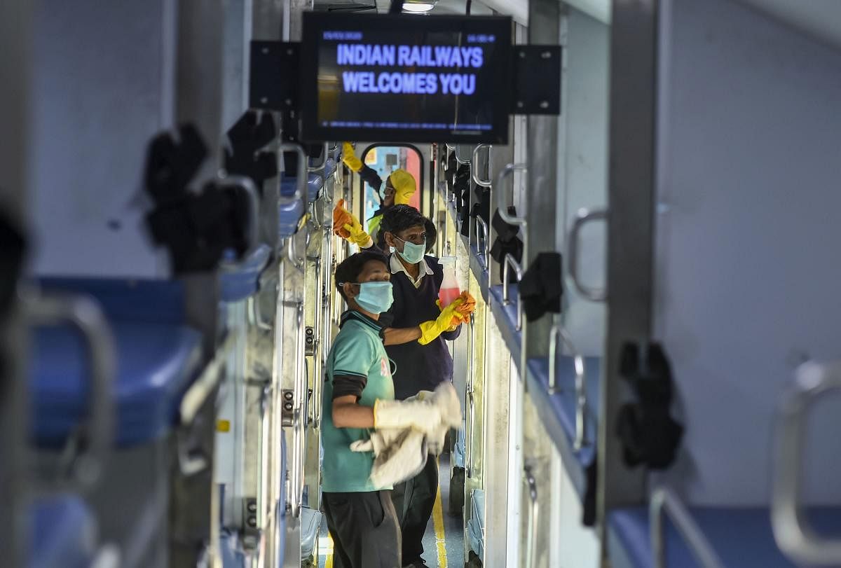 Workers disinfect the coaches of Rajdhani Express in New Delhi on Sunday. The railways has withdrawn blankets and curtains from AC coaches as they are not washed daily. PTI