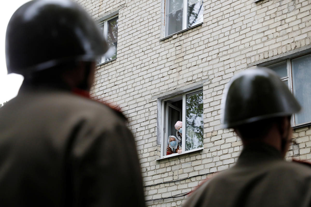 Local residents look out of the window during a military parade organized personally for World War Two veteran Pavel Zakharchenko in Stavropol. Reuters