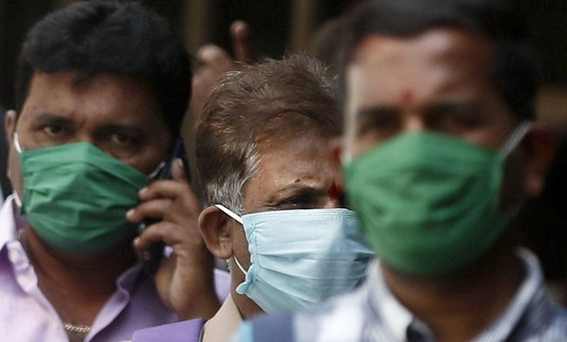 Men wearing protective masks walk inside the premises of a hospital where a special ward has been set up for the coronavirus disease in Mumbai. (Reuters Photo)
