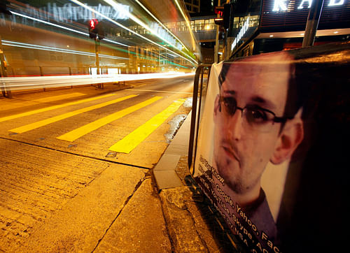 A bus passes by a poster of Edward Snowden, a former contractor at the National Security Agency (NSA), displayed by his supporters at Hong Kong's financial Central district during the midnight hours of June 18, 2013, while Snowden is engaged in a live chat online believed to be in Hong Kong. The former National Security Agency contractor who revealed the government's top-secret phone and Internet surveillance programs said in an online forum on Monday that he did not expect to get a fair trial in the United States. REUTERS.