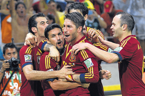 Sea of red: Spain's Jesus Navas (second from left) celebrates with team-mates after scoring the winning penalty against Italy on Thursday. AFP