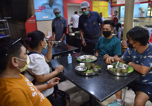 Passengers from Switzerland and hotel staffs wear a mask for safe precaution of Coronavirus at the restaurant at Krantiveera Sangolli Rayanna Railway Station in Bengaluru on Wednesday, March 04, 2020. (DH Photo/Janardhan B K)