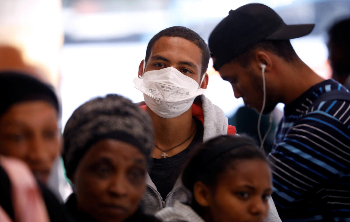 A commuter wears a mask to combat the spread of coronavirus disease (COVID-19) at a bus depot in Cape Town. Credit: Reuters Photo