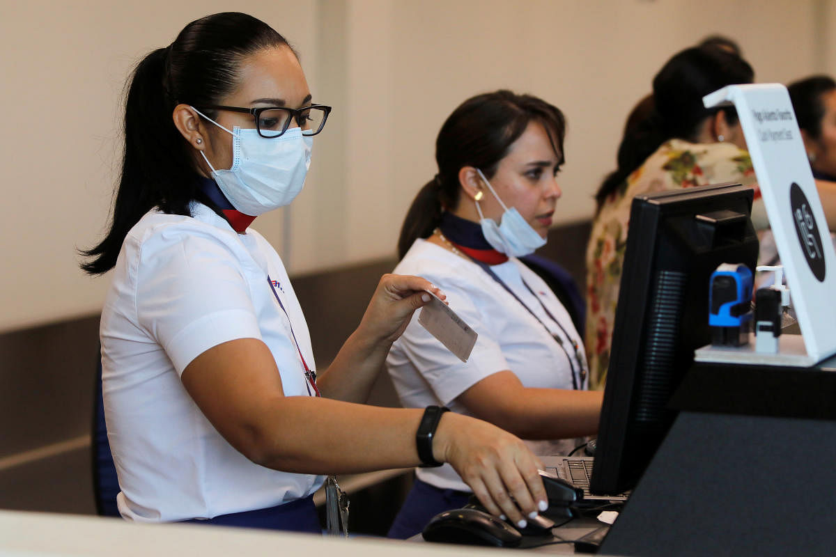 Personnel of Latam Airlines wear protective face masks after a case of coronavirus was confirmed in the country. (Reuters Photo)