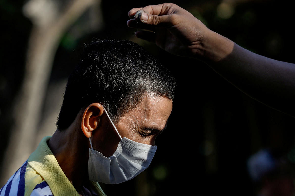 A Filipino Catholic wearing a protective mask receives ash on top of his head as the church observes a "contactless" Ash Wednesday amid the coronavirus scare, at the National Shrine of Our Mother of Perpetual Help, Paranaque City. Credit: Reuters Photo