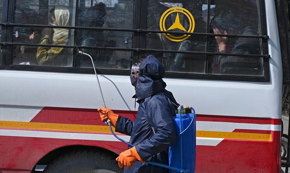 Municipal workers spray disinfectant on a bus amid concerns over the spread of the COVID-19 coronavirus. AFP photo for representation