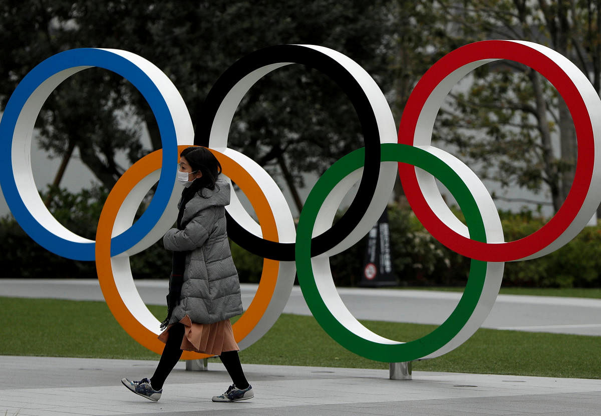  A woman wearing a protective face mask, following an outbreak of the coronavirus disease, walks past the Olympic rings in front of the Japan Olympics Museum, in Tokyo. Credit: Reuters File Photo