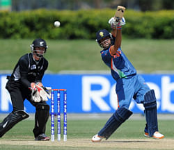 Prashant Chopra, right, of India drives the ball as Cameron Fletcher of New Zealand stands over the stumps during their ICC U19 Cricket World Cup semi-final match, Thursday, Aug. 23, 2012 in Townsville, Australia. (AP Photo