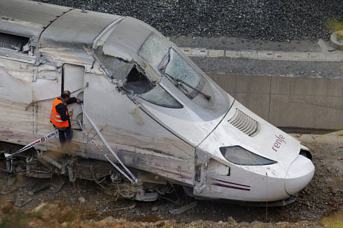 A rail personnel worker checks the cabin of a derailed train following an accident in Santiago de Compostela, Spain. A Spanish court official said Monday July 29, 2013 that judicial police would soon begin extracting information from the "black box" of a train that crashed last week killing 79 people and injuring some 130 in the country's worst train accident in decades. It is hoped the box might establish what happened in the final seconds prior to the crash. The investigation has increasingly focused on why the driver failed to brake in time to stop the train from hurtling into a dangerous curve, where it careered off the tracks and slammed into a concrete wall. On Monday, Spain's royal family and leading politicians were to attend a somber Mass in homage to the victims killed and injured. (AP Photo)