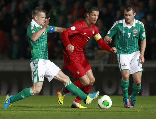 Portugal's Cristiano Ronaldo (C) is challenged by Northern Ireland's Steven Davis (L) and Niall McGinn (R) during their 2014 World Cup qualifying soccer match at Windsor Park Stadium in Belfast September 6, 2013. REUTERS