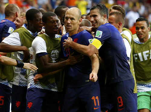 Arjen Robben of the Netherlands (C) and teammate Robin van Persie (R) celebrate their goal against Spain during their 2014 World Cup Group B soccer match at the Fonte Nova arena in Salvador June 13, 2014. REUTERS