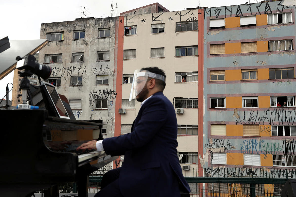 Pianist Rodrigo Cunha serenades from an open truck the lonely mothers in quarantine as the spread of the coronavirus disease (COVID-19) continues in Sao Paulo. Reuters