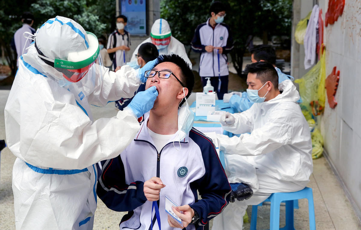 Workers collect swabs from senior high school students for nucleic acid tests in Wuhan (Reuters Photo)