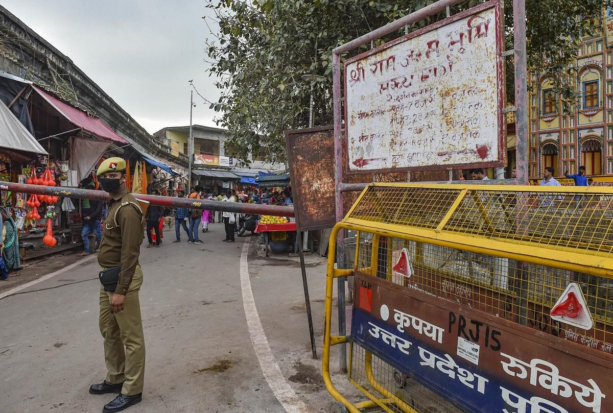 A police person wearing protective mask in the wake of coronavirus pandemic stands guard at a check-post near Ramlala market in Ayodhya, Saturday, March 14, 2020. (PTI Photo)