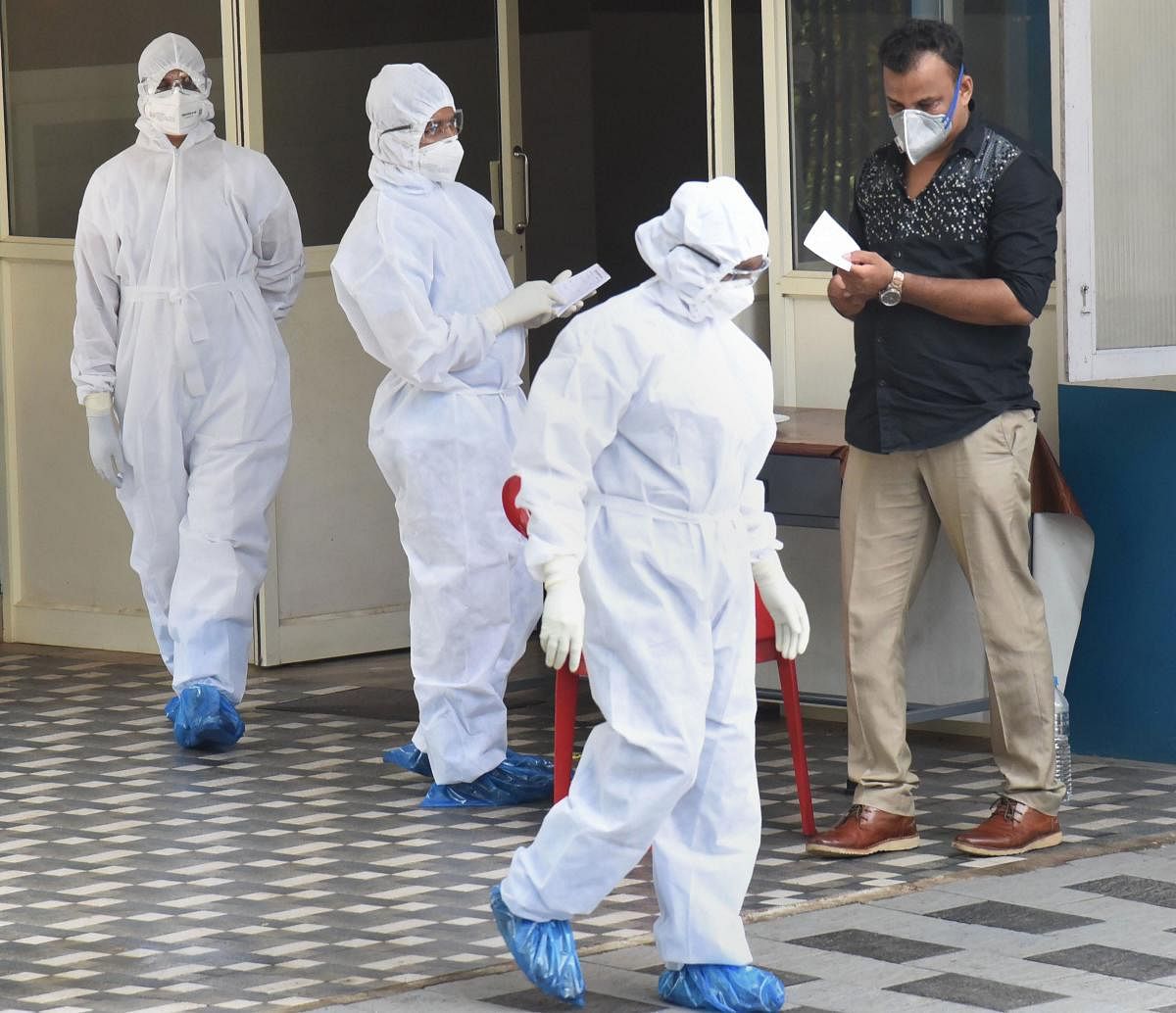  Medical staff members wear masks and protective suits to mitigate the spread of coronavirus, outside the special isolation ward of District Hospital Aluva in Kochi. PTI
