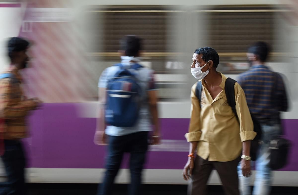 Passengers wearing face masks, as a measure to prevent coronavirus spread, are seen waiting at CST railway station, in Mumbai, Friday, March 20, 2020. (PTI Photo)