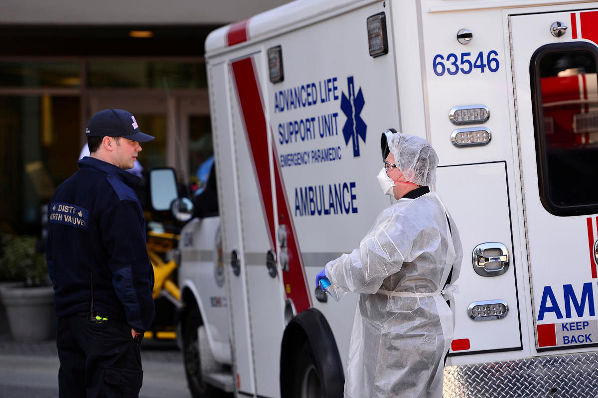 A firefighter (left) and a paramedic (right) speak outside the Lynn Valley Care Centre, a seniors care home which housed a man who was the first in Canada to die after contracting novel coronavirus, is seen in North Vancouver, British Columbia, Canada March 9, 2020. (Reuters Photo)