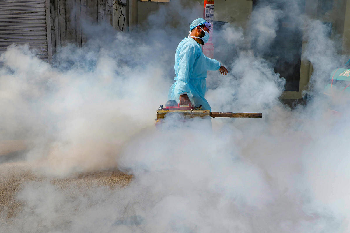  A Jammu Muncipal Corporation worker spray disinfectant on a street during Janta curfew in the wake of deadly coronavirus, in Jammu, Sunday, March 22, 2020. (PTI Photo)