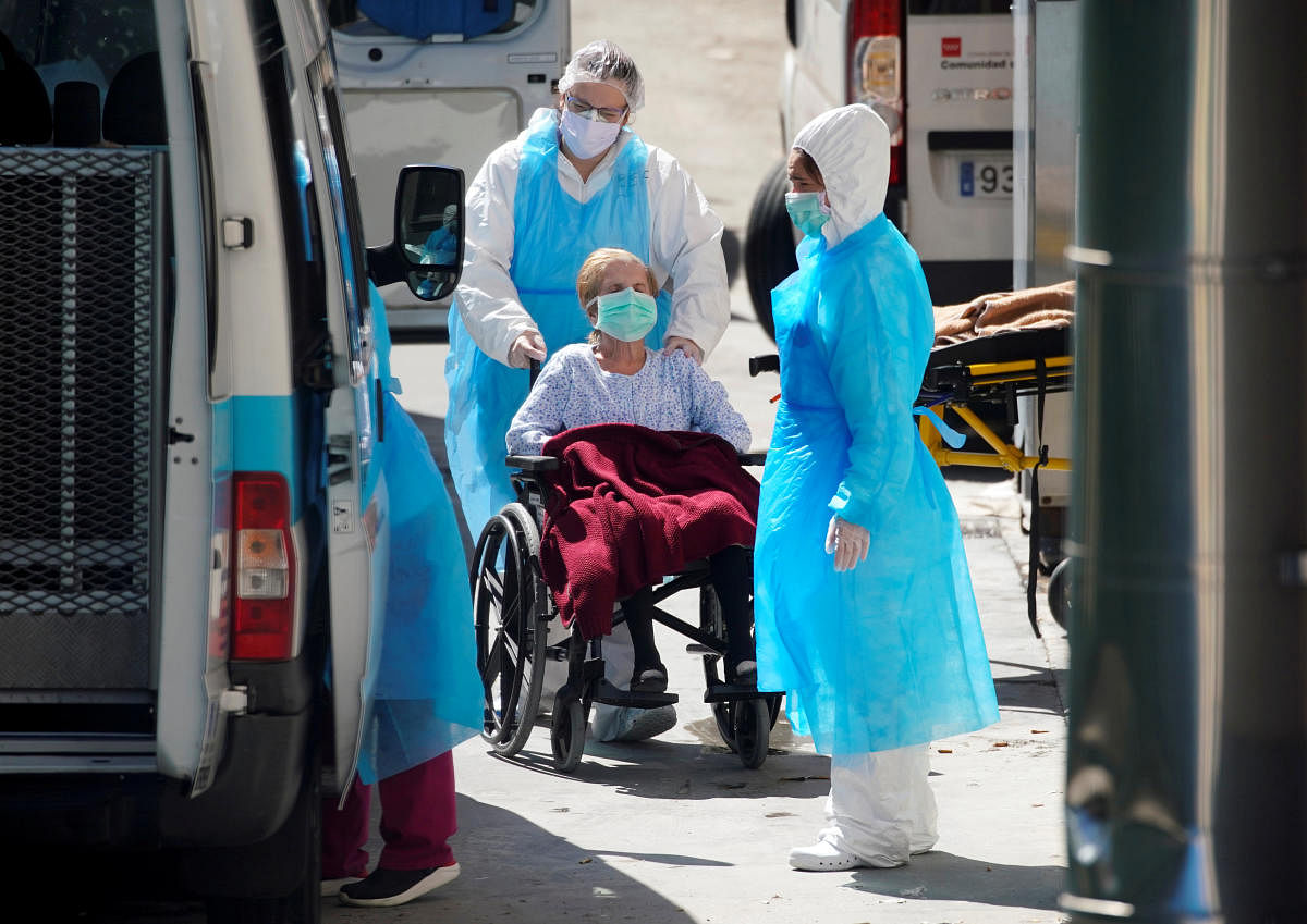  Ambulance workers push a wheelchair with a patient at a nursing home during the coronavirus disease (COVID-19) outbreak in Leganes Madrid, near Madrid, Spain, April 2, 2020. REUTERS/Juan Medina/File Photo